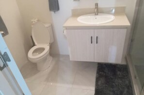 Chuveiro, toalhas de banho, papel higiênico