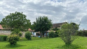 A rural property with stone walls, a grassy yard, and a small house with a tiled roof. - La Petite Maison, charming 3 bedroom Gite in Saint-Estephe, 24360, Dordogne, (Saint-Estèphe)