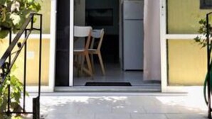 Een woongebouw met een schuifdeur die uitkomt op een kleine keuken met een tafel en stoelen.