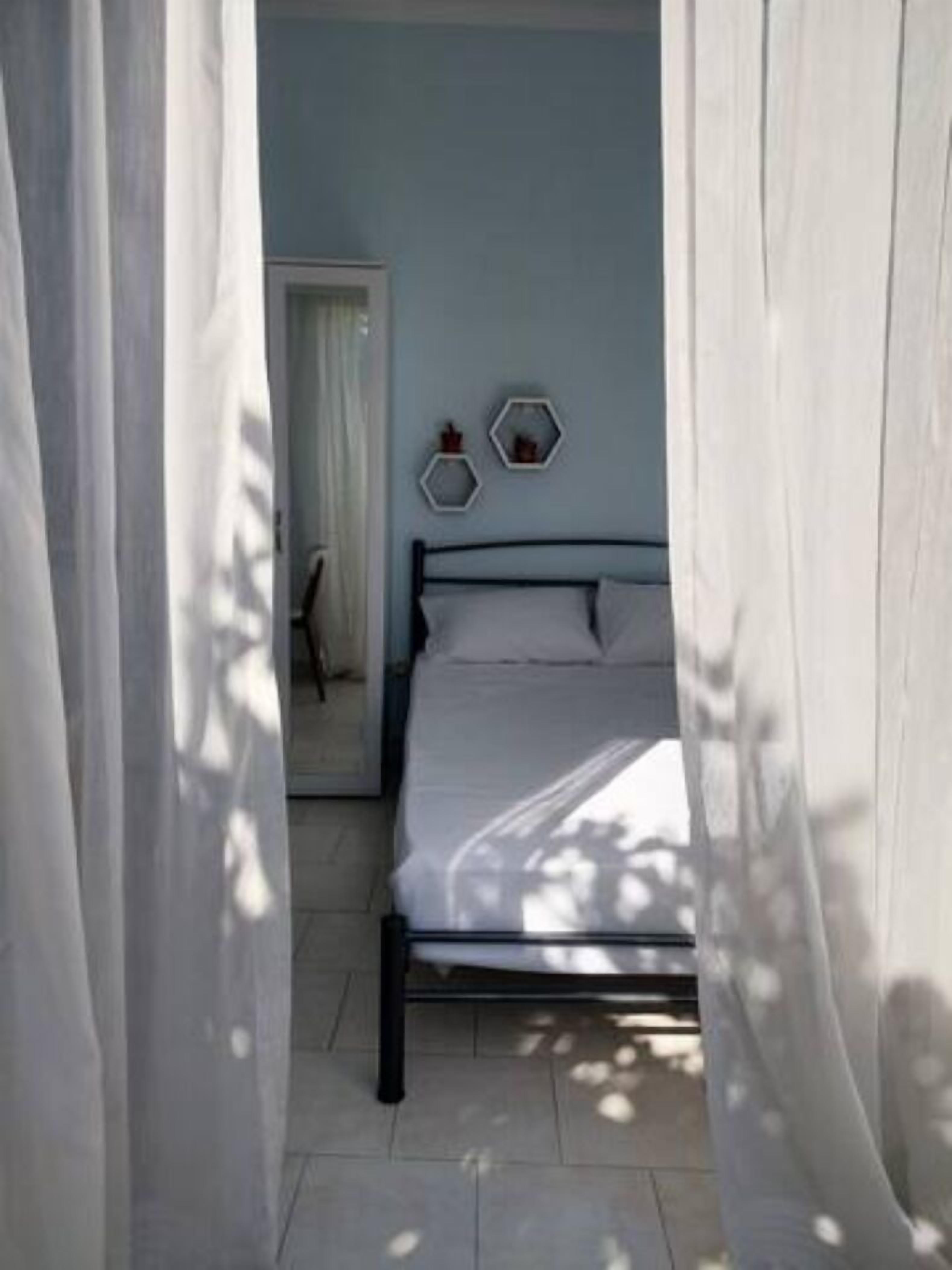 A bedroom with a bed, curtains, and two hexagonal wall decorations.