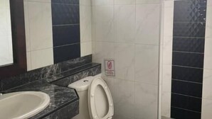 A bathroom with a white toilet, a sink, and a mirror. - Bluewhale Home Samui (Koh Samui)