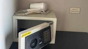 A corner of a hotel room with a microwave, a telephone, and a sign indicating a swimming pool. - Bluewhale Home Samui (Koh Samui)