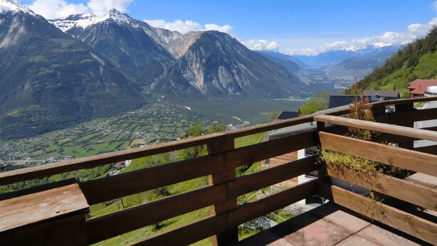 A wooden bench overlooking a mountainous landscape with a valley and a river. - Hotel Rhoneblick (Guttet-Feschel)