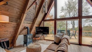 Een knus loft slaapkamer met een groot raam, een open haard en een gezellige zithoek.