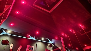 A room with a sloped ceiling, red lighting, and a framed picture. - AKA LOVE ROOM (Lavaur)