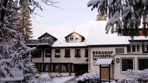 Un edificio cubierto de nieve con un letrero que dice "BERGHOF INNBRIEG".