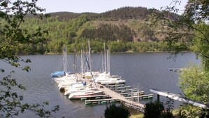 Un puerto deportivo con varios veleros amarrados a un muelle de madera.