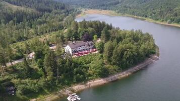 Un hotel rodeado de bosque y un lago, con vistas al paisaje.