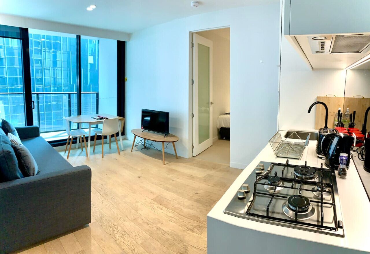 A modern apartment with a living room, dining area, and kitchen.