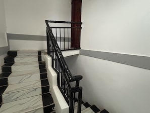 A staircase with black and white tiles, a black railing, and a wooden door. - 5 Bedroom Lodge Sleeps 10 - Pets Welcome (Kitanswa)