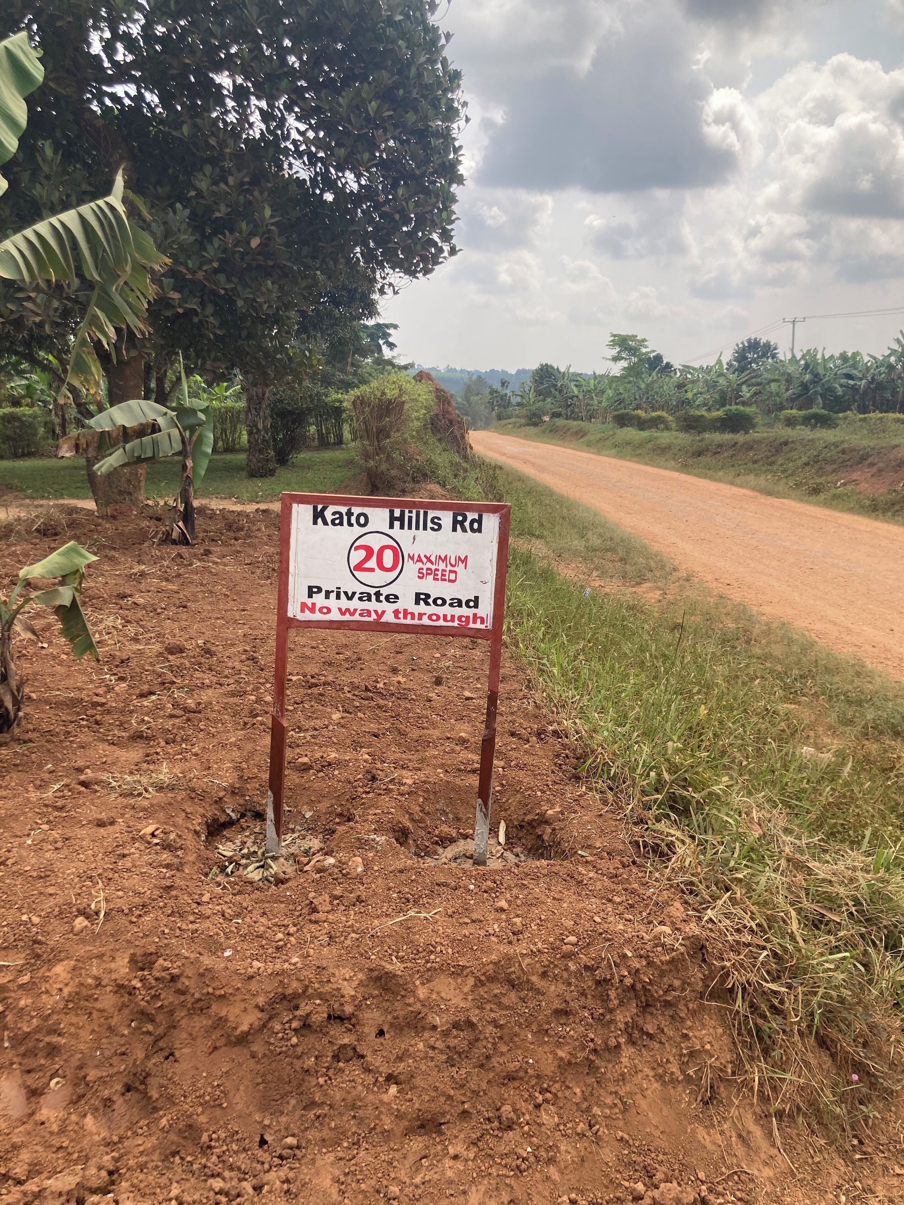 A dirt road with a sign indicating 'Kato Hills Rd' and '20 MAXIMUM SPEED No way through.'
