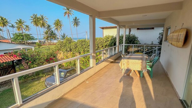 Un balcón con vista a palmeras y un paisaje lejano.