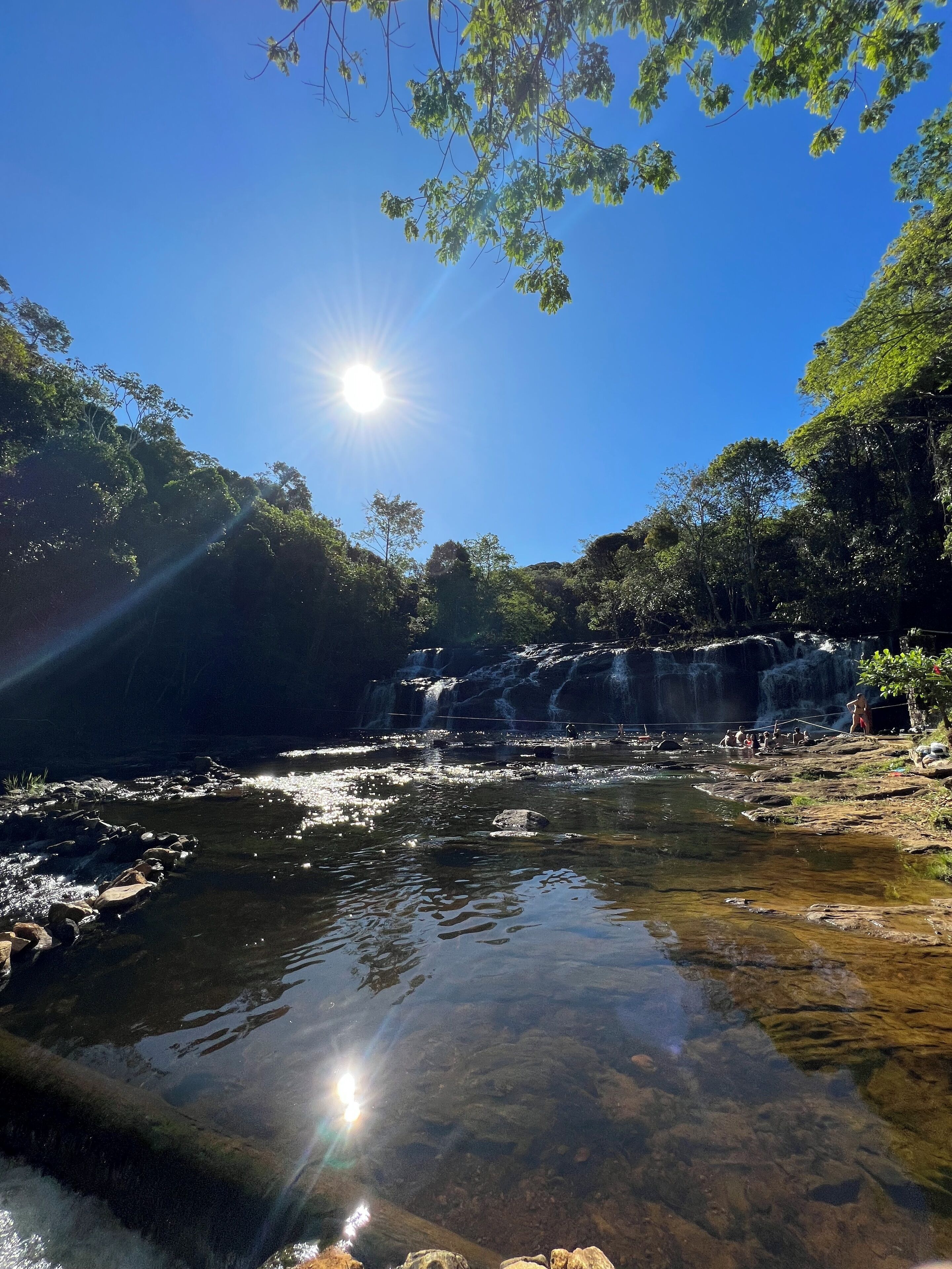 Una vista despejada de un paisaje natural con una cascada, un río tranquilo y abundante vegetación.