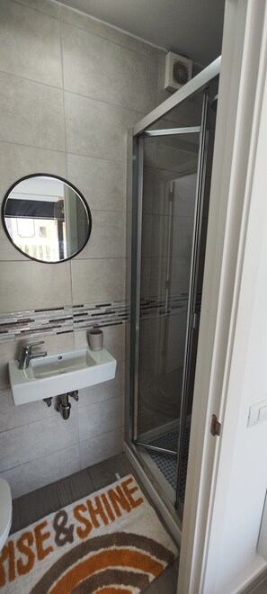 Een douche, een haardroger, handdoeken, toiletpapier
