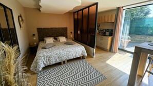 A bedroom with a bed, bedside tables, a dresser, and a view of the outside. - Le diX - Classic Room - Vallabrix (Vallabrix)