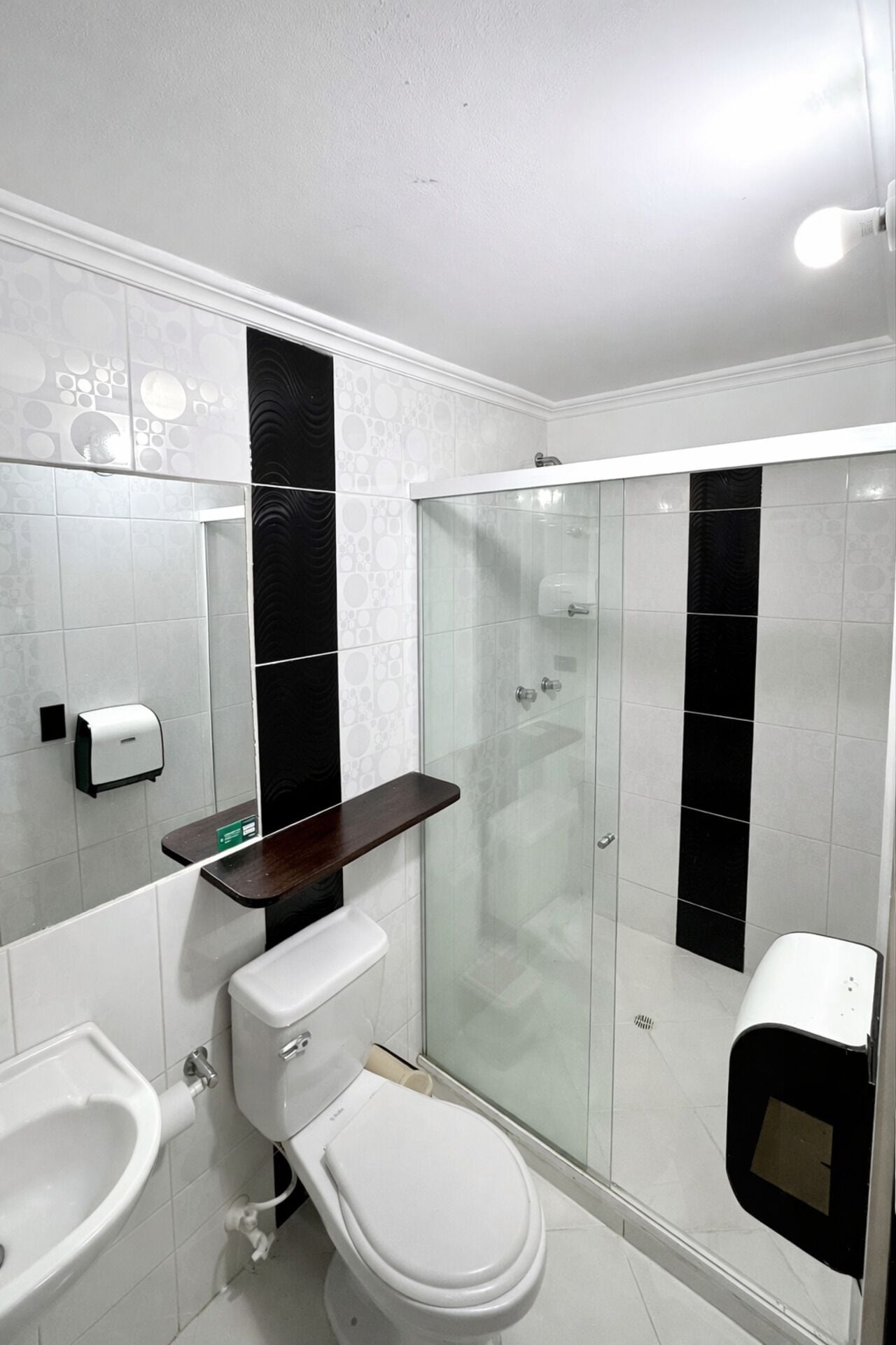 A modern bathroom with a toilet, bidet, and glass-enclosed shower.