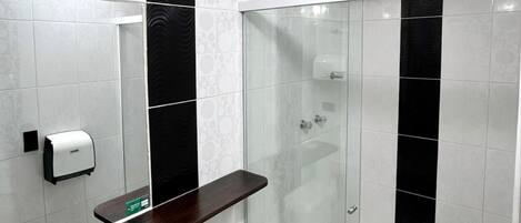 A modern bathroom with a toilet, bidet, and glass-enclosed shower.