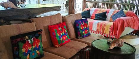 A rustic outdoor seating area with a wooden bench and colorful cushions.