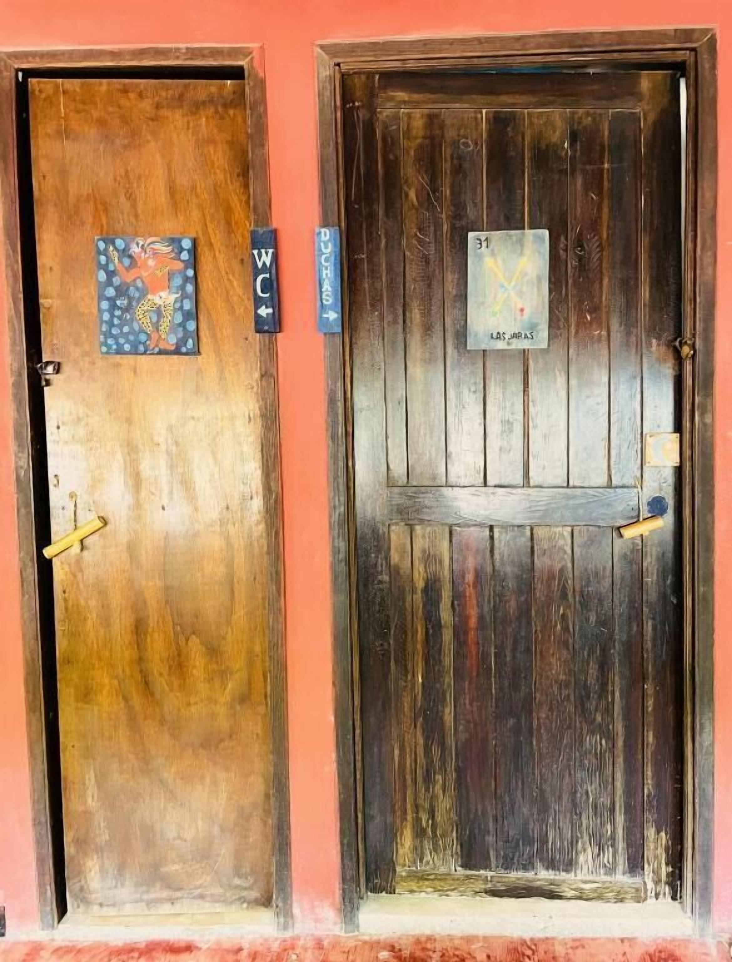 Two wooden doors with signs indicating "WC" and "Las Jaras".