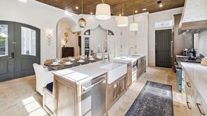 A spacious kitchen with a central island, wooden ceiling, and pendant lighting. - Dreamy retreat—5-min to beach, private pool, LSV, & home theater | Sleeps 20! (Seagrove Beach)