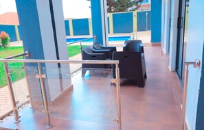 Relax by the pool in a tranquil outdoor seating area with a clear view of the adjacent pool.