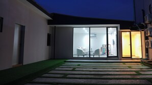 A modern house with a glass door leading to a dining area. - Majestic Courts (Lagos)