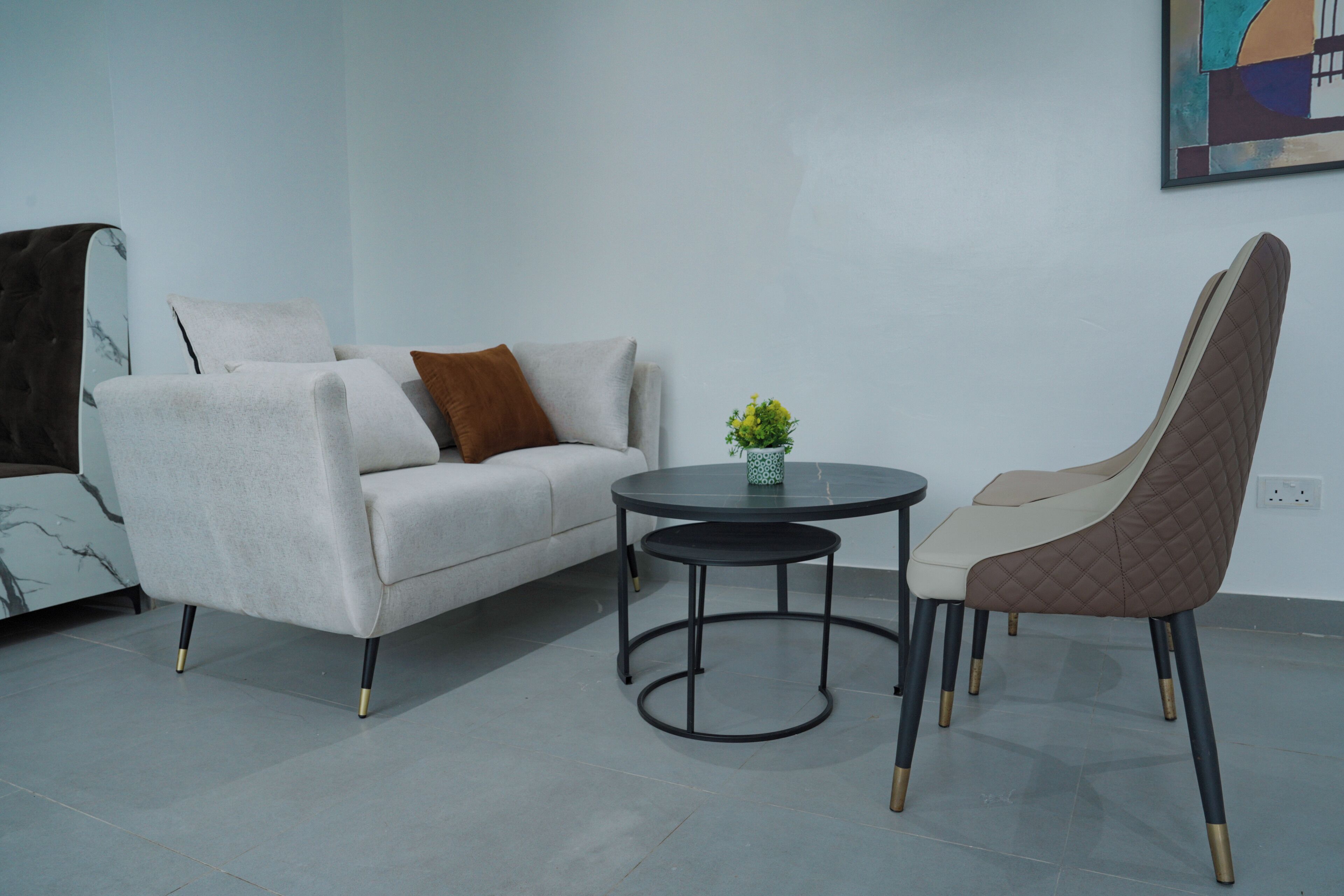 A modern living room with a sofa, a round table, and a chair.