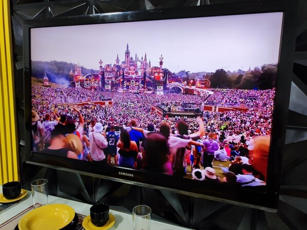 A television displaying a crowd at a large event with a castle-like structure in the background.