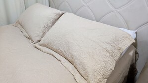 Una cama con cabecera acolchada y almohadas.