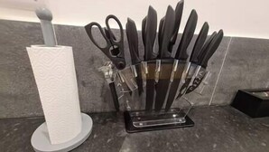 A kitchen counter with a paper towel holder and a knife block. - Split level luton town center flat (Luton)