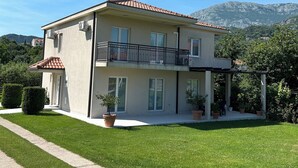 Ein zweistöckiges Gebäude mit Balkon, überdachter Veranda und Bergblick.