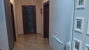 Ein Flur mit Fliesenboden, einem Heizkörper und einer Tür mit Verzierungen.