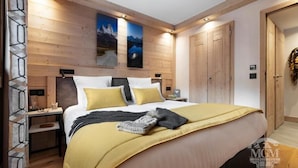 Ein modernes Hotelzimmer mit einem großen Bett, Holzwandverkleidung und zwei Bildern.