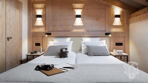 A wooden-paneled room with two beds, nightstands, and wall-mounted lighting. - Wifi, view mountain, fitness, swimming pool, sauna, hammam, balcony, tv, ski locker, 88m², Valmorel (Valmorel)