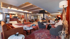 Eine moderne Hotelhalle mit verschiedenen Sitzbereichen, einer Bar und einer Rezeption.