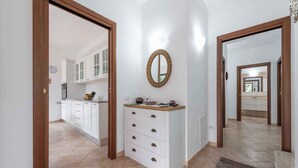 A hallway with a kitchen and a bathroom visible through an open door. - Villa La Fata in the country village (Stintino)