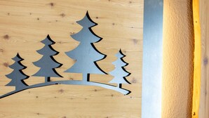 A wooden headboard with a cut-out tree design and white pillows. - Holiday apartment with wellness area (Ötz im Ötztal)