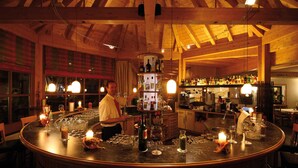 A bar area with a wooden ceiling, bar counter, and various bottles and glasses. - Holiday apartment with wellness area (Ötz im Ötztal)