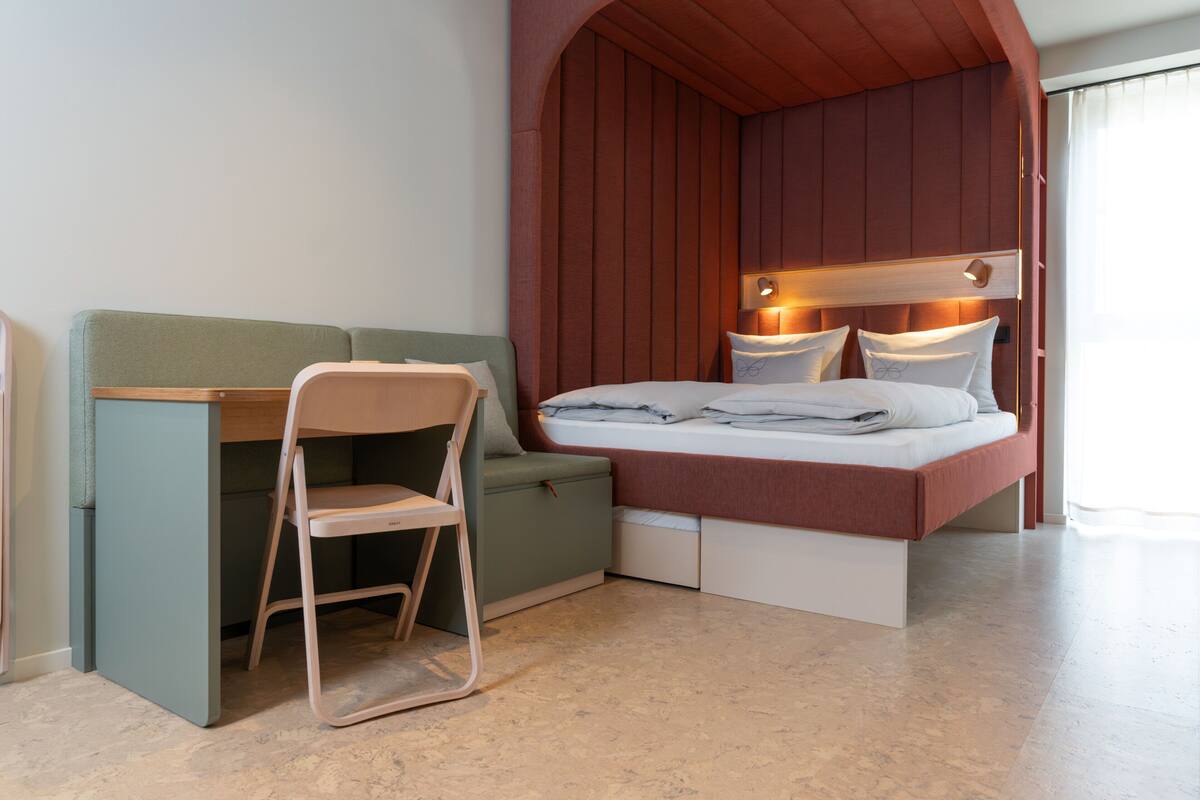 A room with a bed, a desk, and a chair.