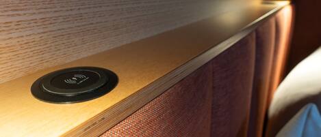 Un panel de madera con un panel de control circular, una pared con textura y una luminaria suave.