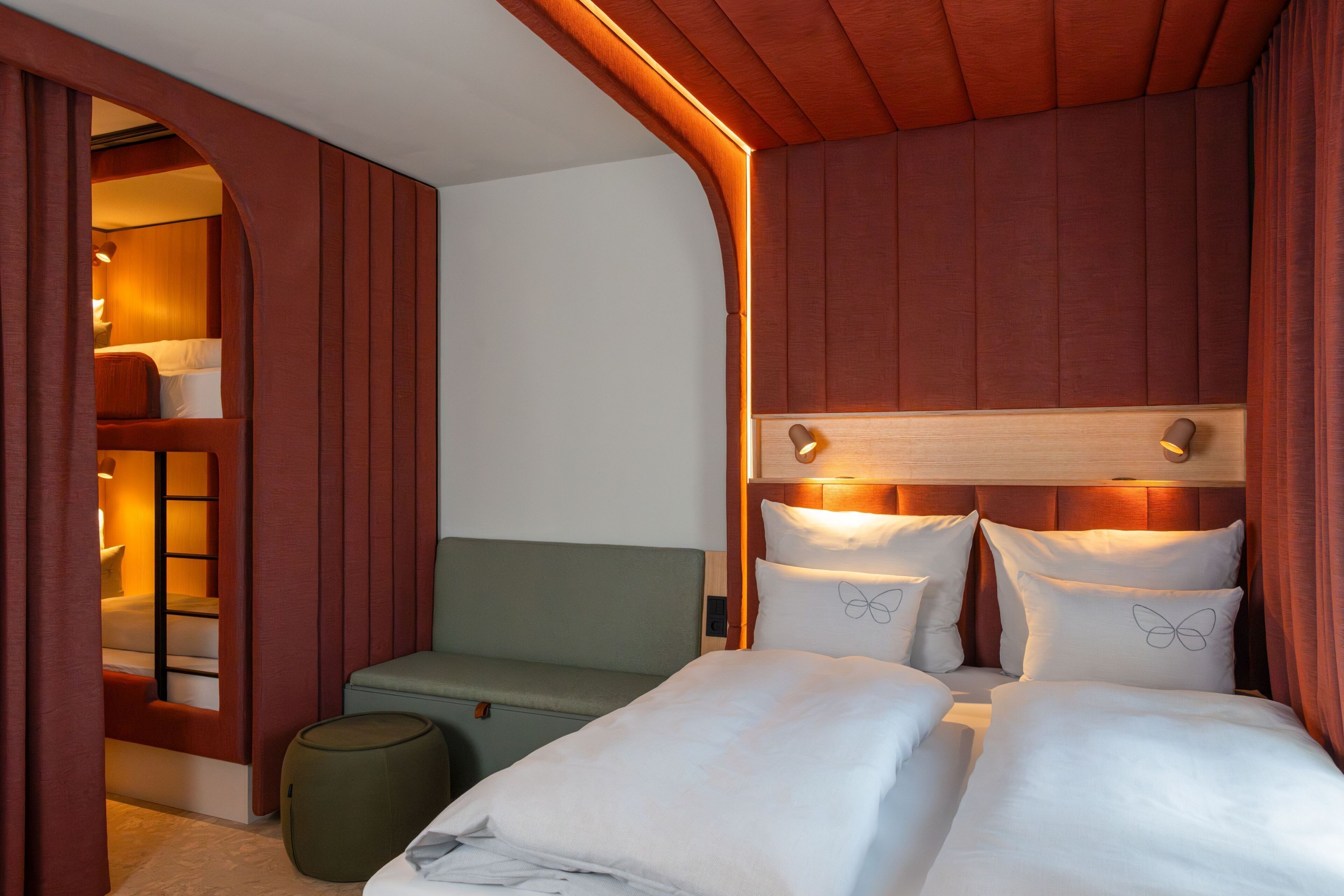 A hotel room with a bed, a seating area, and a small table.