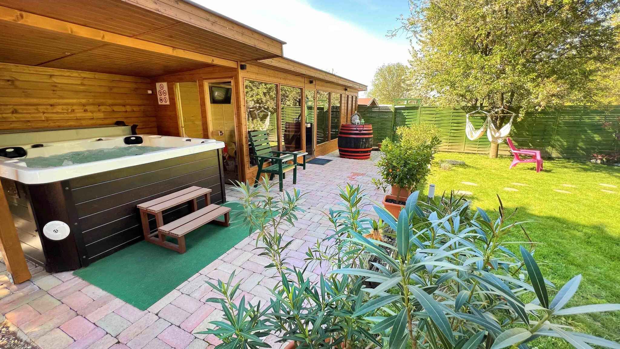 A wooden spa building with a hot tub, outdoor seating, and a garden.