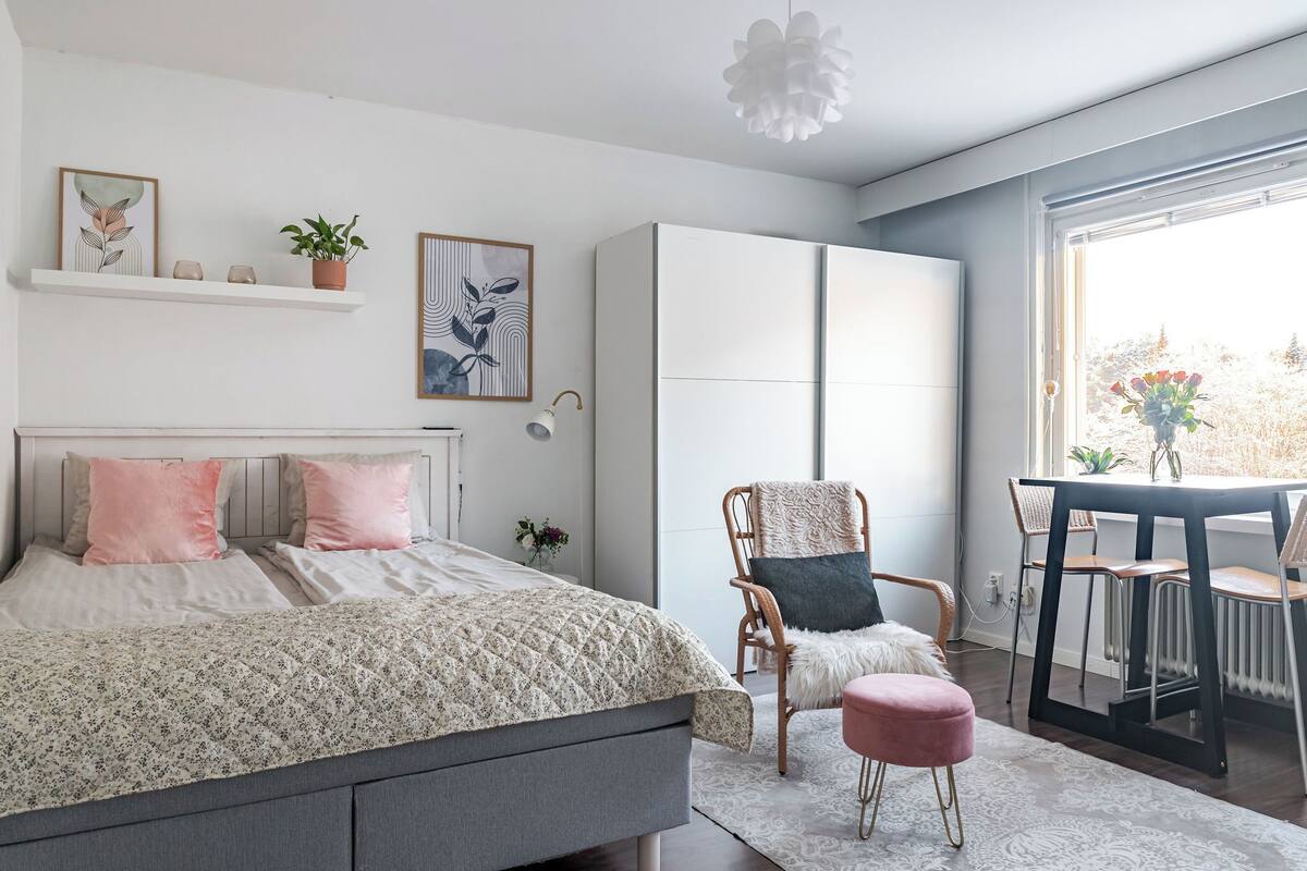 Une chambre à coucher moderne avec un lit, une chaise, une table et une fenêtre donnant sur un beau paysage.