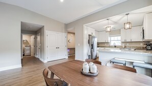 A spacious kitchen with white cabinets, a large island, and modern appliances. - Traverse City Flats (Williamsburg)