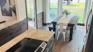 Une cuisine dotée d’un comptoir en granit, d’appareils électroménagers en acier inoxydable et offrant une vue sur l’extérieur.