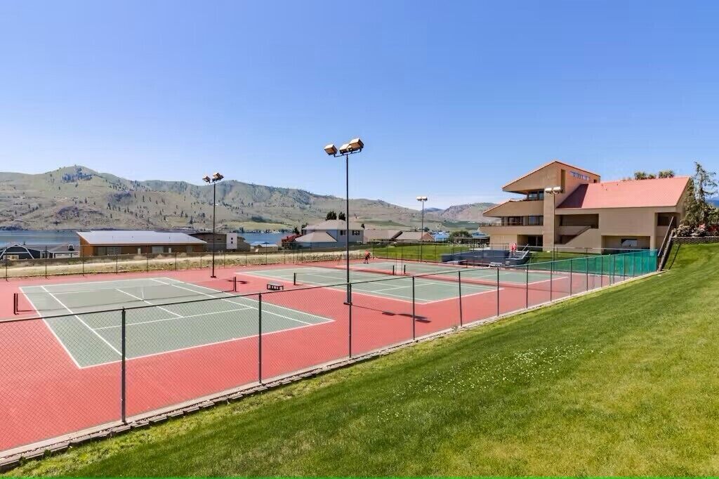 Un court de tennis avec un bâtiment en arrière-plan.