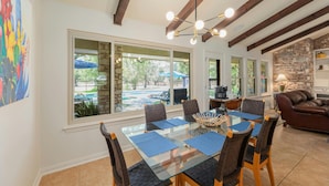 A dining area with a glass table, chairs, and a view of the outdoors. - Beautiful Pool home on 2.5 acres with a serene country feel with urban location (Round Rock)