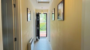 A hallway with a radiator, a door, and a window leading to an outdoor area.