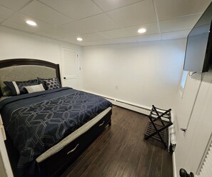 A bedroom with a bed, a radiator, and a TV mounted on the wall. - Enjoy easy access to this  4 Bedroom smart home in downtown Hazleton PA.   (Hazleton)