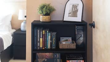 Une bibliothèque remplie de livres, un tableau encadré et une petite plante.